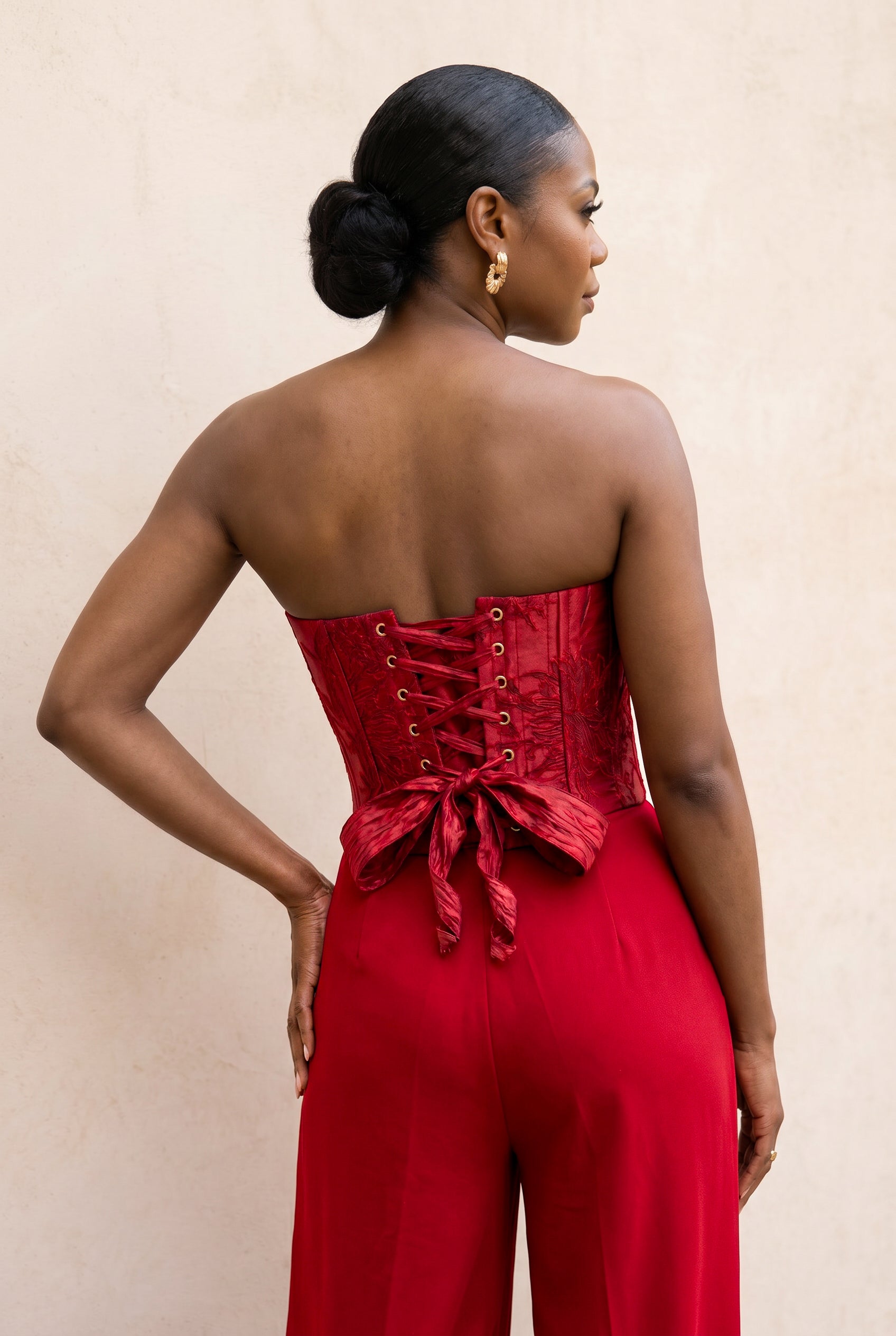 Back view of crimson floral jacquard corset with adjustable lace-up closure.